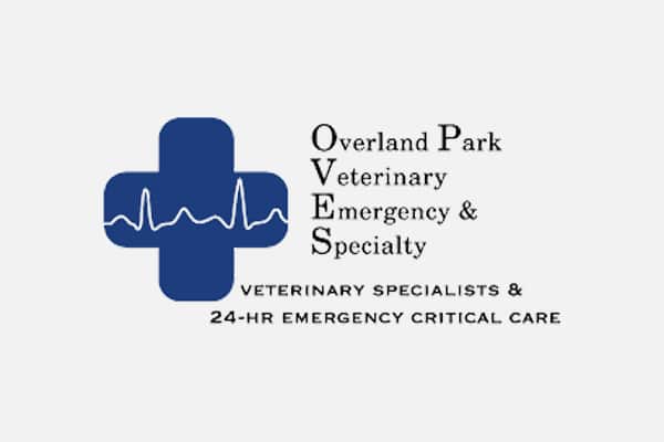 Logo for Overland Park Veterinary Emergency & Specialty Animal Hospital, featuring a blue medical cross with a white ECG line and the clinic name in black text. Below, it says "Veterinary Specialists & 24-HR Emergency Critical Care.